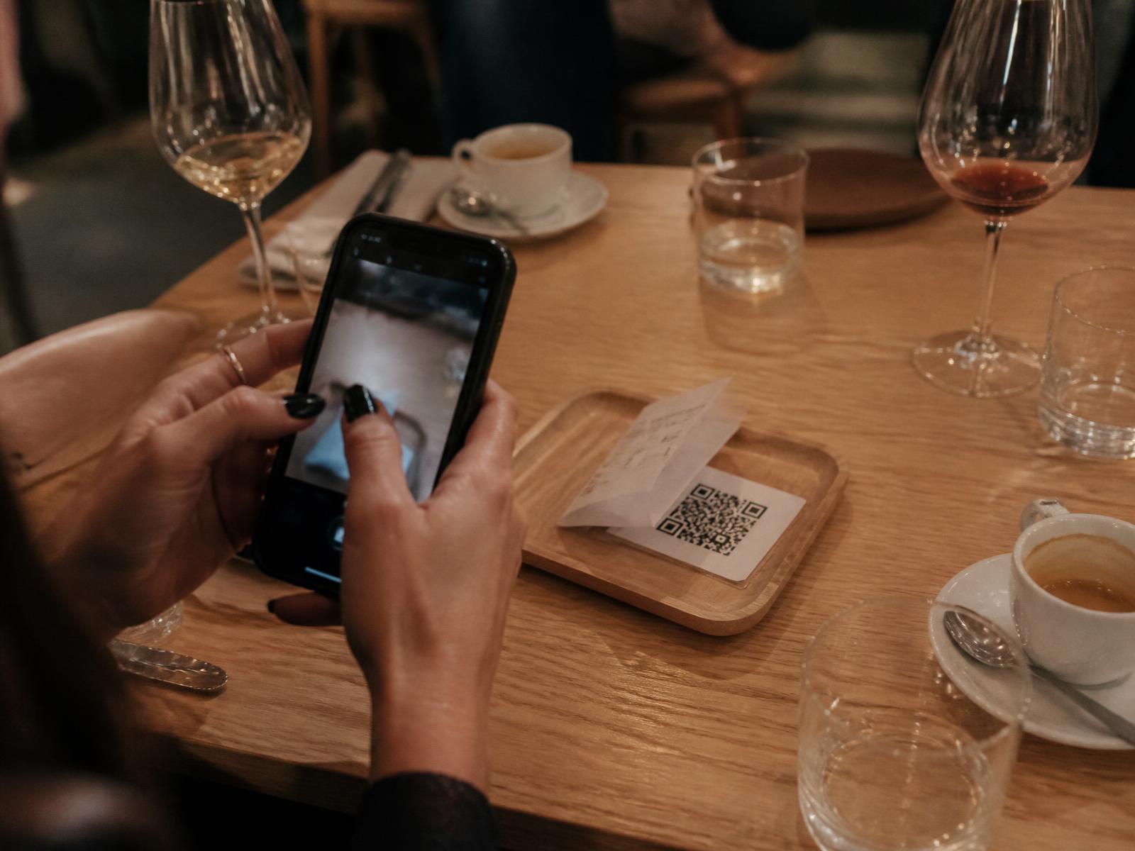Waiter placing the bill with a QR code on a restaurant table